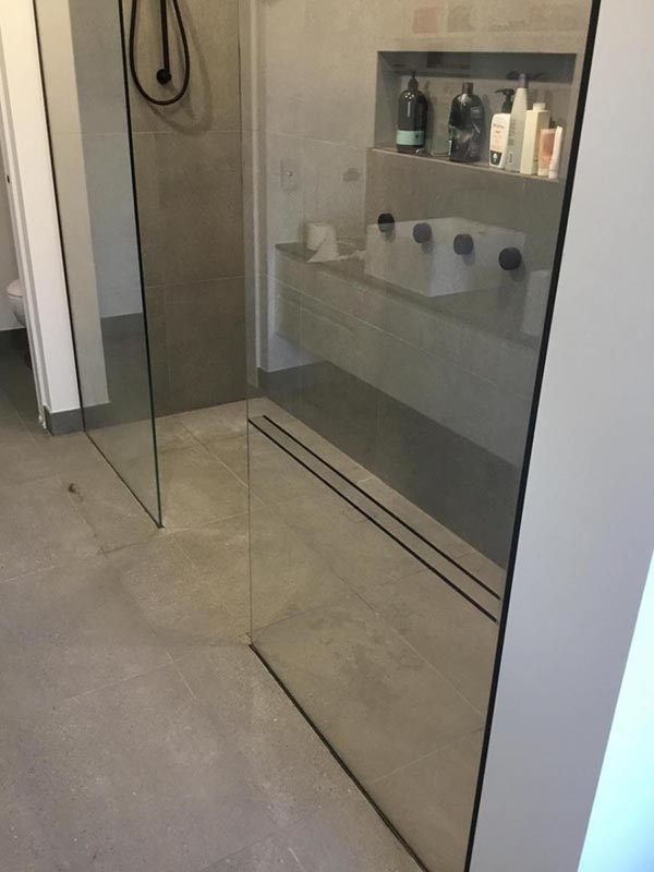 Double shower area with concealed track drain