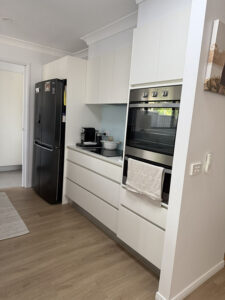 New kitchen with hybrid flooring and glass splashback