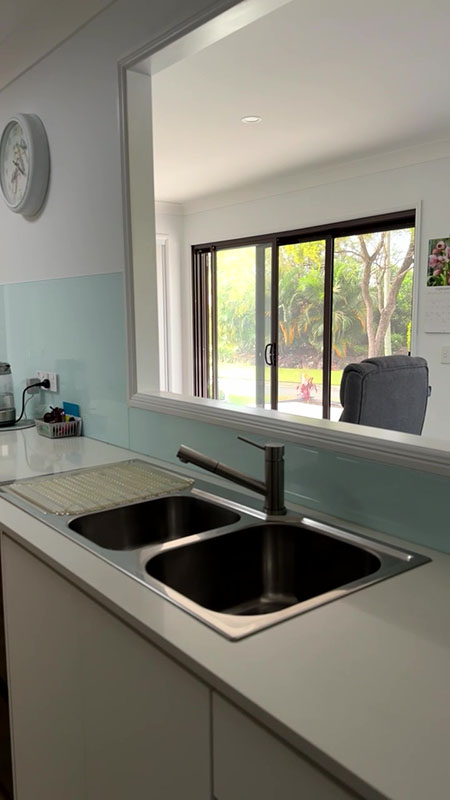 Kitchen with a window opening to sun-room area