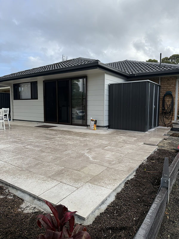 Backyard image showing house extension with hardie-plank exterior walls and completed roof