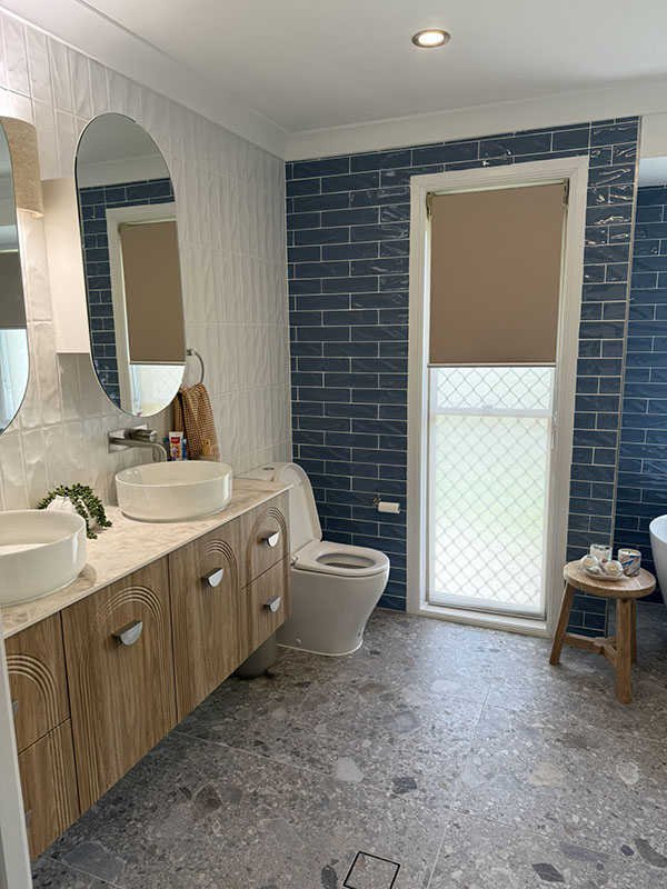 Bathroom tiled in blue and white subway tiles with double basin vanity unit