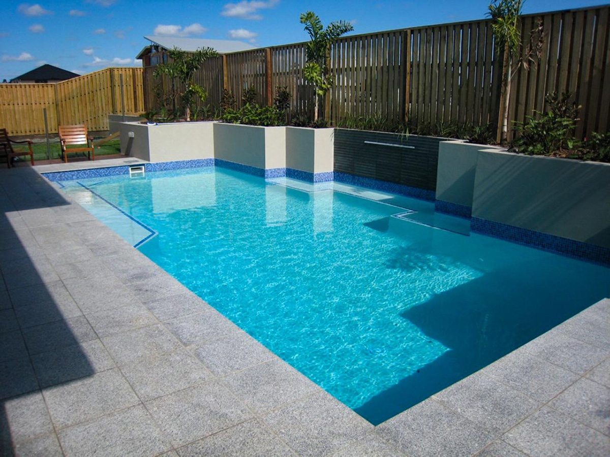 Tiled pool area with raised garden bed along fenceline