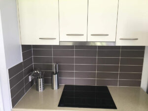 Kitchenette with a 4 element cook-top and subway tiled backsplash